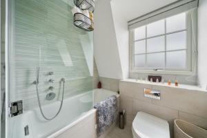 a bathroom with a shower and a toilet and a sink at Marble Arch Penthouse 1 Bed in London