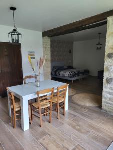 a dining room with a table and chairs and a bed at Le Clos in Corcelles-les-Monts