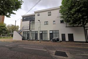 a white building with glass windows on a street at Cosy Coastal Haven 1-Bedroom Apartment in Southend-On-Sea - Southend Stays in Southend-on-Sea