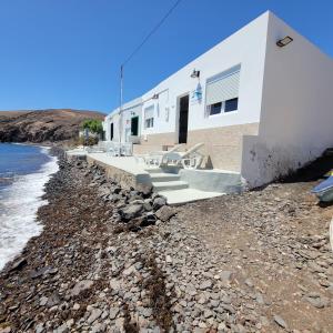 a white house on the shore of the beach at Casa Cetáceo in Playa Quemada