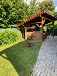 a wooden pavilion with a table and chairs in a yard at Apartmány Lucie in Karlovice