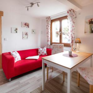 a living room with a red couch and a table at Ferienwohnung Rose in Westerburg