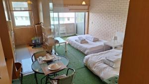 Zimmer mit 2 Betten, einem Tisch und Stühlen in der Unterkunft Deluxe Studio in a Great Area by Douro River in Vila Nova de Gaia