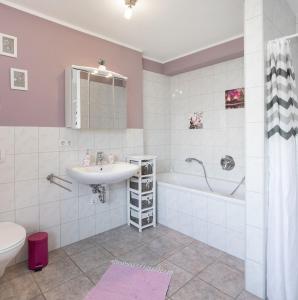 a bathroom with a sink and a tub and a toilet at Ferienwohnung Rose in Westerburg