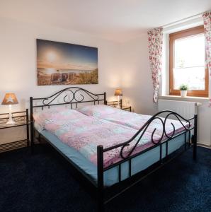 a bedroom with a bed and two windows at Ferienwohnung Rose in Westerburg