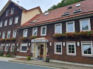 un edificio de madera con flores a un lado en Hotel Zum Pass, en Sieber