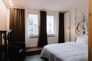 Chimay : La Chambre Rouge de la Grand Place في كيماي: غرفة نوم بسرير ومكتب ونوافذ