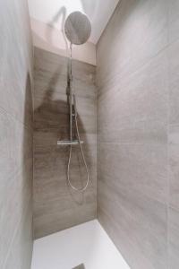 La salle de bains est pourvue d'une douche avec un pommeau de douche. dans l'établissement Chimay : La Chambre Rouge de la Grand Place, à Chimay