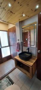 baño con lavabo negro y espejo en Acogedor apartamento cerca del teleférico amarillo, en La Paz