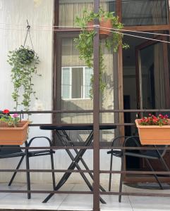 a table and chairs on a porch with potted plants at happy home in Borjomi