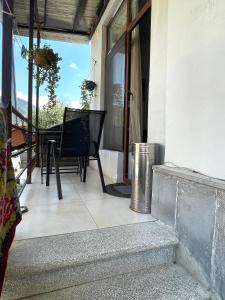 un balcone con tavolo e sedie su una casa di happy home a Borjomi