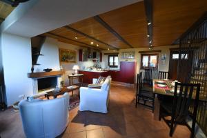 uma cozinha e sala de estar com mesa e cadeiras em Maison des Roses - Family Farm em Bossolasco
