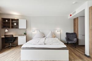 Schlafzimmer mit einem Bett, einem Schreibtisch und Stühlen in der Unterkunft Home and CoLiving Bonn I Aparthotel I Soft Opening in Bonn
