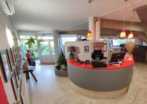 um escritório com um balcão vermelho no meio de uma sala em Hotel Les Gravades Ussel em Ussel