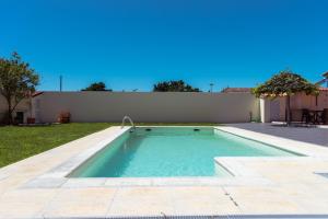a small swimming pool in a yard with a fence at Retiro da Atafona Beach Pool House Yellow 