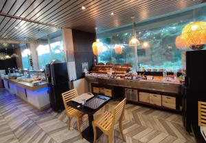 a restaurant with a counter with a table and chairs at Logis Hotel Les Gravades Ussel in Ussel