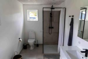 La salle de bains est pourvue d'une douche, de toilettes et d'un lavabo. dans l'établissement Liljeparken 30, à Otterup