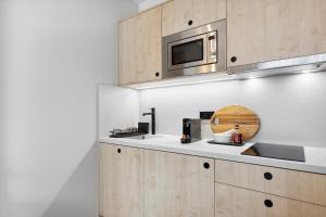 a kitchen with a sink and a microwave at Home and CoLiving Bonn I Aparthotel in Bonn