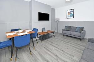 - un salon avec une table, des chaises et un canapé dans l'établissement Barnstone Villa - By Sigma Stays, à Crewe