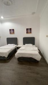 two beds in a room with white walls at تذكار in Qal'at Bishah