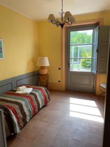 1 dormitorio con cama, ventana y puerta en In Campagna, en Santa Fiora
