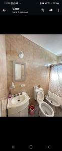 een badkamer met een wastafel, een toilet en een spiegel bij Departamento en Villaguay in Villaguay