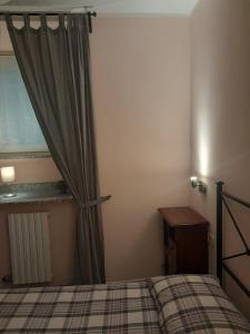 L'Incanto dell'Airone في مالغراتي: غرفة نوم بسرير وستارة وطاولة