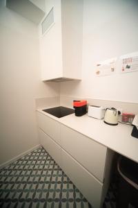 a kitchen with white cabinets and a black sink at Private room By BCN Center in Barcelona