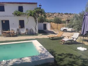 un patio trasero con piscina y una casa en Casa Rural Puente de la Vicaria by Jaxun, en Yeste