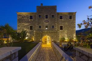 un gran edificio de piedra con entrada en Itilo Traditional Hotel en Neon Oitilon