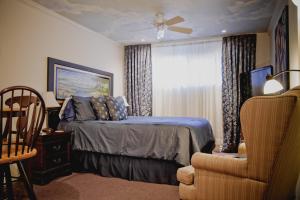a bedroom with a bed and a window and a chair at Maison Des Jardins B & B in Montréal