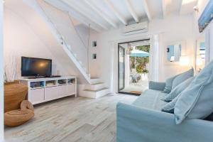 a living room with a blue couch and a tv at Bluehouse Portixol in Palma de Mallorca