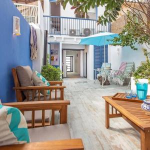 a patio with benches and an umbrella and a table at Bluehouse Portixol in Palma de Mallorca