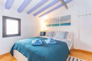 1 dormitorio con 1 cama con toallas en Bluehouse Portixol, en Palma de Mallorca