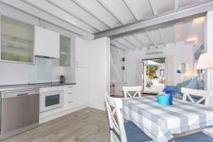 a kitchen and dining room with a table and chairs at Bluehouse Portixol in Palma de Mallorca