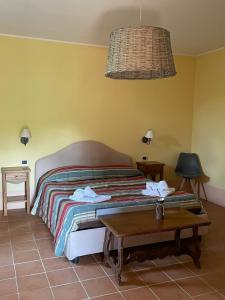 1 dormitorio con 1 cama con mesa y lámpara en In Campagna, en Santa Fiora