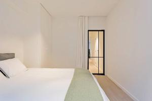 a bedroom with a white bed and a sliding glass door at Sun & sea Knokke in Knokke-Heist