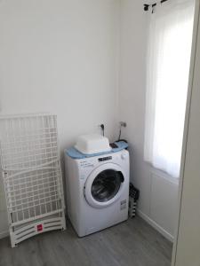 een wasmachine en droger in een kamer met een raam bij Appartamento Veses in Santa Giustina