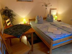 a small bedroom with a bed and a table at Pension zur Heiligen Krone in Mauterndorf