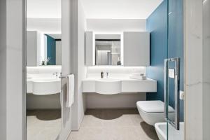 a bathroom with two sinks and a toilet at Limehome Milan via Stresa in Milan