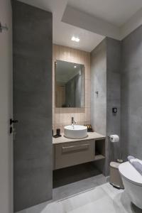 a bathroom with a sink and a toilet and a mirror at Studio w/king size bed near the Heart of Kalamata in Kalamata