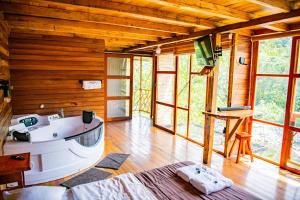 Habitación con paredes de madera y baño con bañera. en RioVida EcoLodge, 