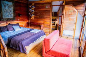 a bedroom with a bed and a chair at RioVida EcoLodge in Nueva Tarqui