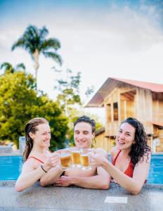 un grupo de tres personas sosteniendo una bandeja de cerveza en RioVida EcoLodge, 