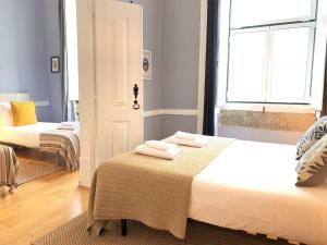 a room with two beds with towels on a table at SJ2D Central Baixa NEW AIR CONDITIONING Spacious and Friendly in Lisbon