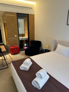 een hotelkamer met een bed met handdoeken erop bij Golden Lisbon Hotel in Lissabon