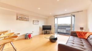 a living room with a couch and a television at High Quays - Properties Unique in Newcastle upon Tyne