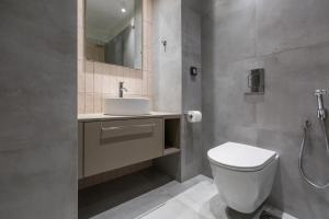 a bathroom with a toilet and a sink and a mirror at Studio w/king size bed near the Heart of Kalamata in Kalamata