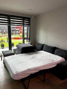a bedroom with a large bed and a couch at A modern & homely apartment in Reykjavík