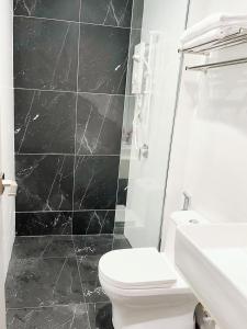 Baño blanco con aseo y lavamanos en The Beacon Executive @Penang Georgetown en George Town